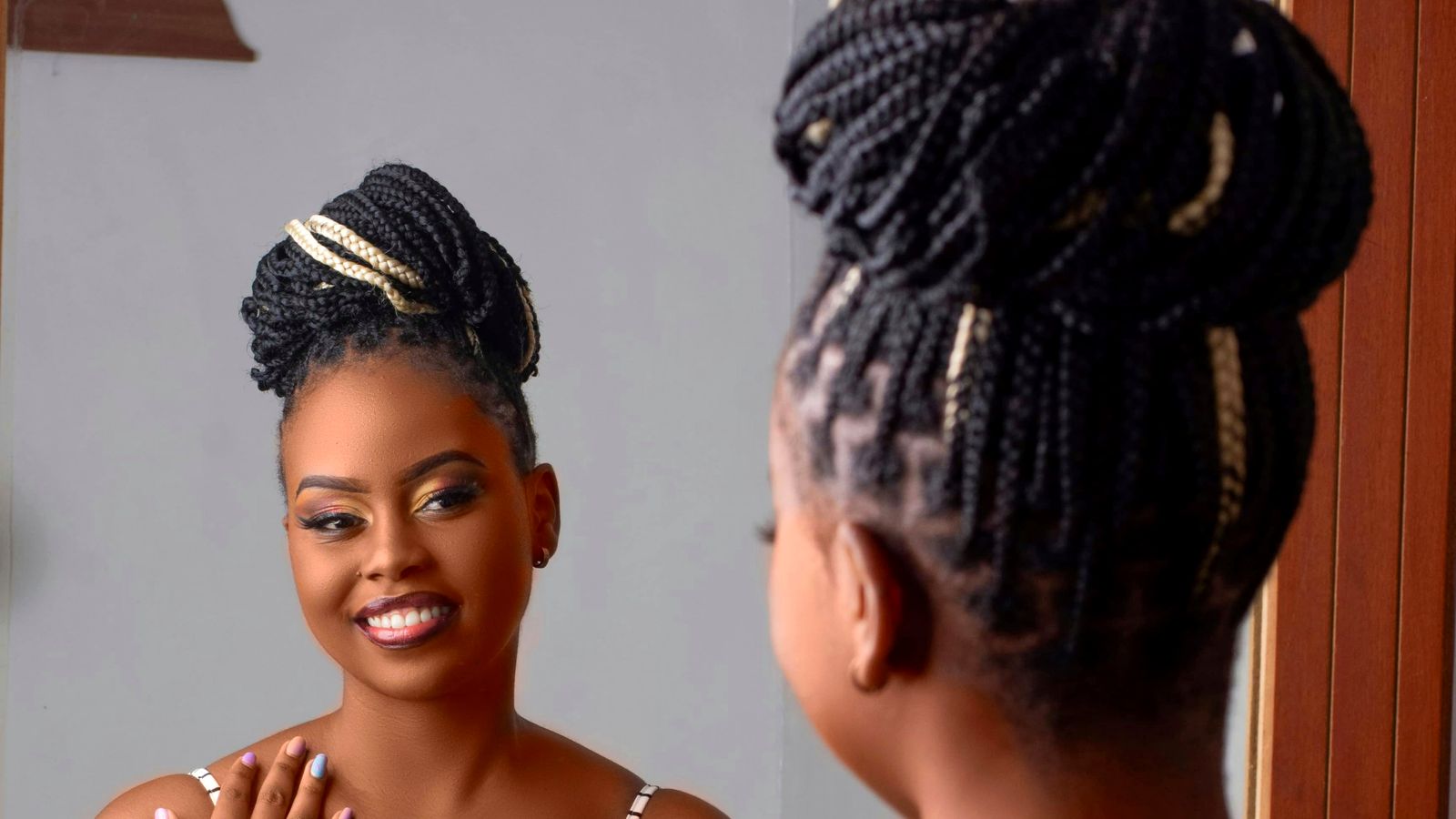 Black woman smiling at her own reflection